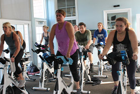 men and women in a spin class