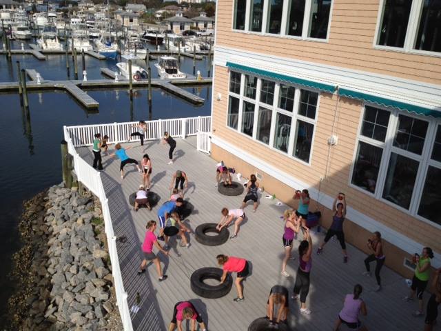 gym members working out on gym deck with fitness tires