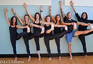 women in synchronized yoga pose in gym studio