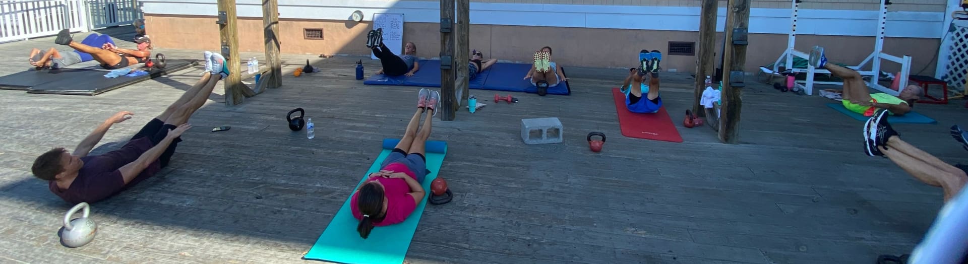gym members work out on the back deck at inlet fitness during an outdoor cross training fitness class