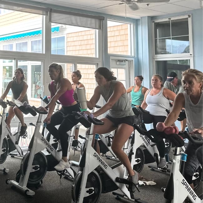gym members use stationary bikes during a spinning class at inlet fitness