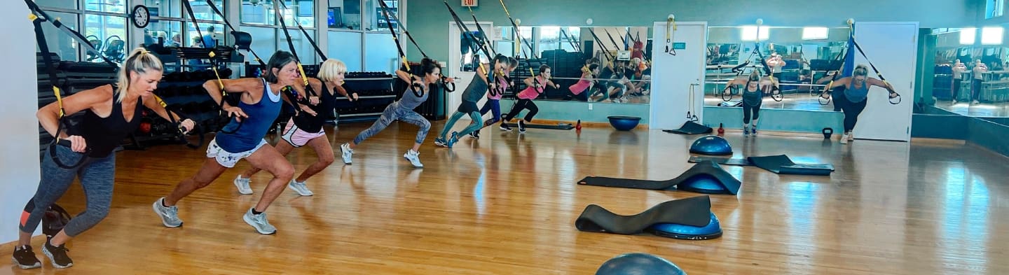 gym members work out in a group fitness TRX class at inlet fitness in virginia beach